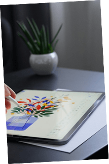 Floral illustration being drawn on a tablet beside a potted plant